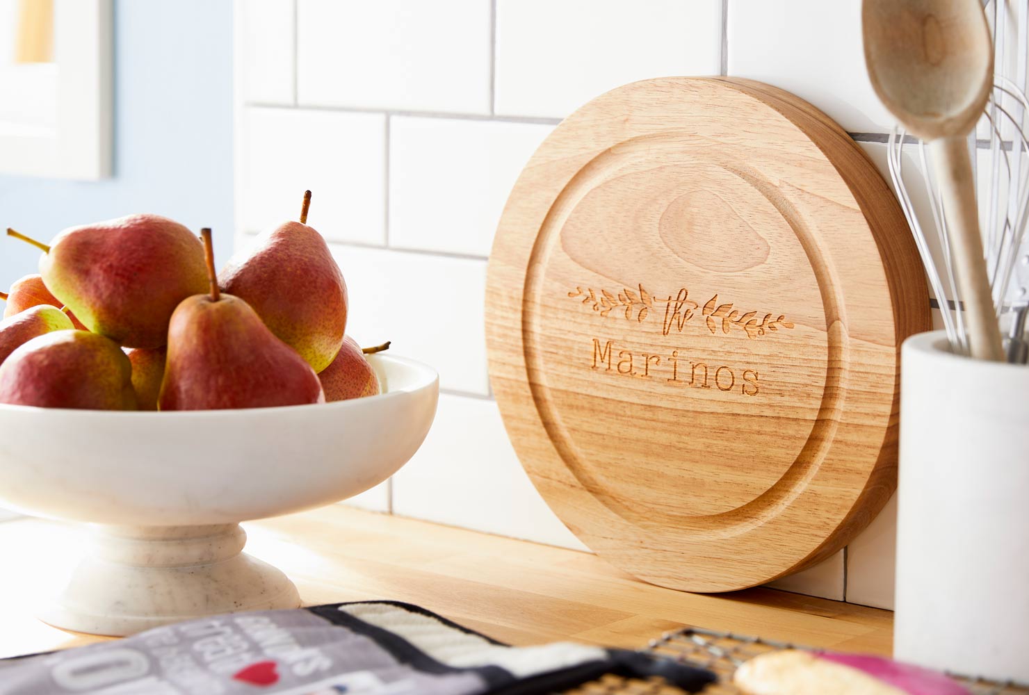 Monogrammed wooden cutting board on counter.