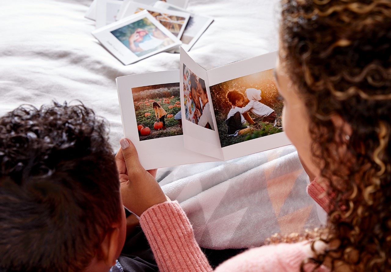 mom and child looking at a shutterfly mini photo book together